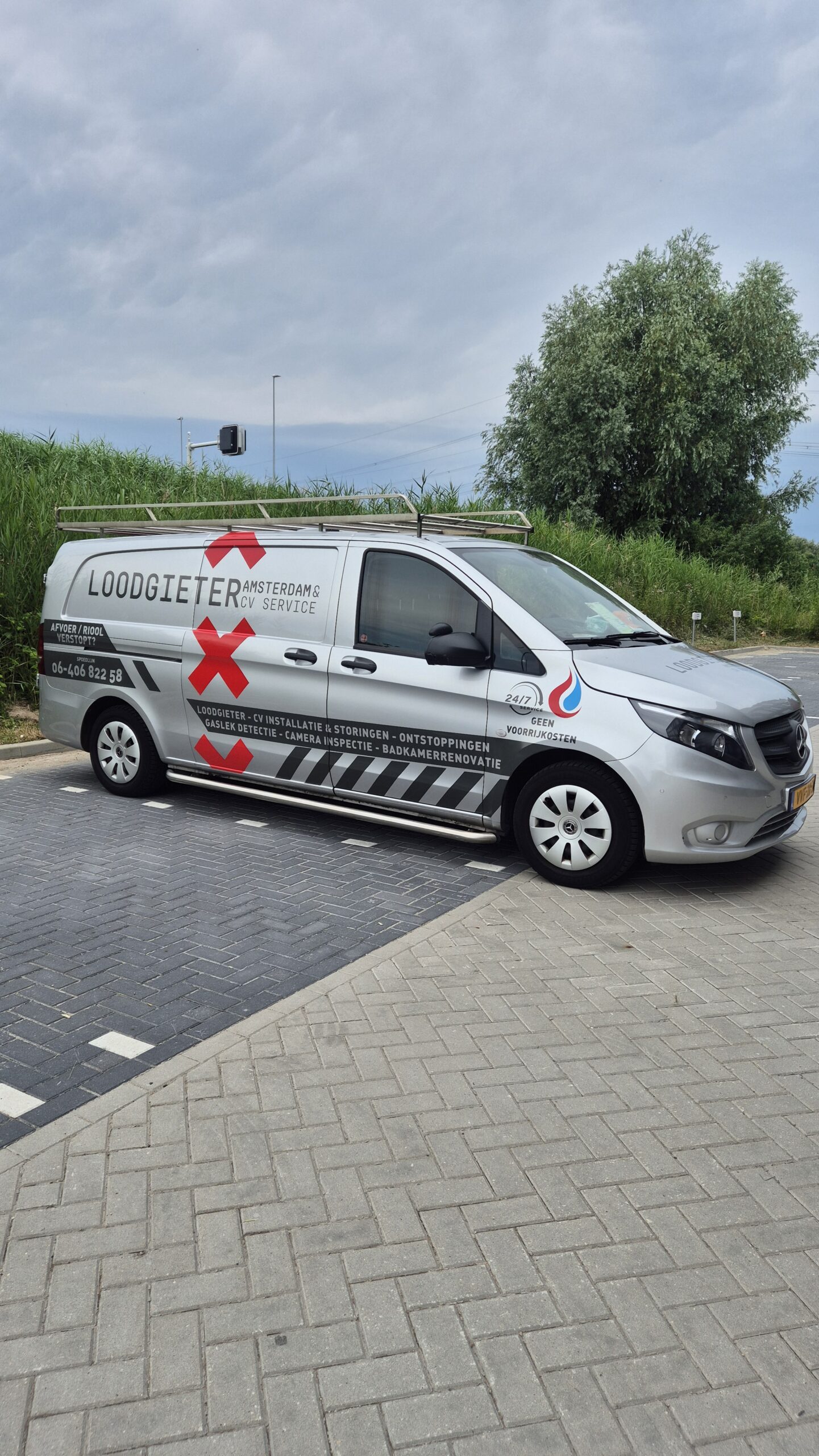 1000121578 Bestelbus met belettering op een parkeerterrein