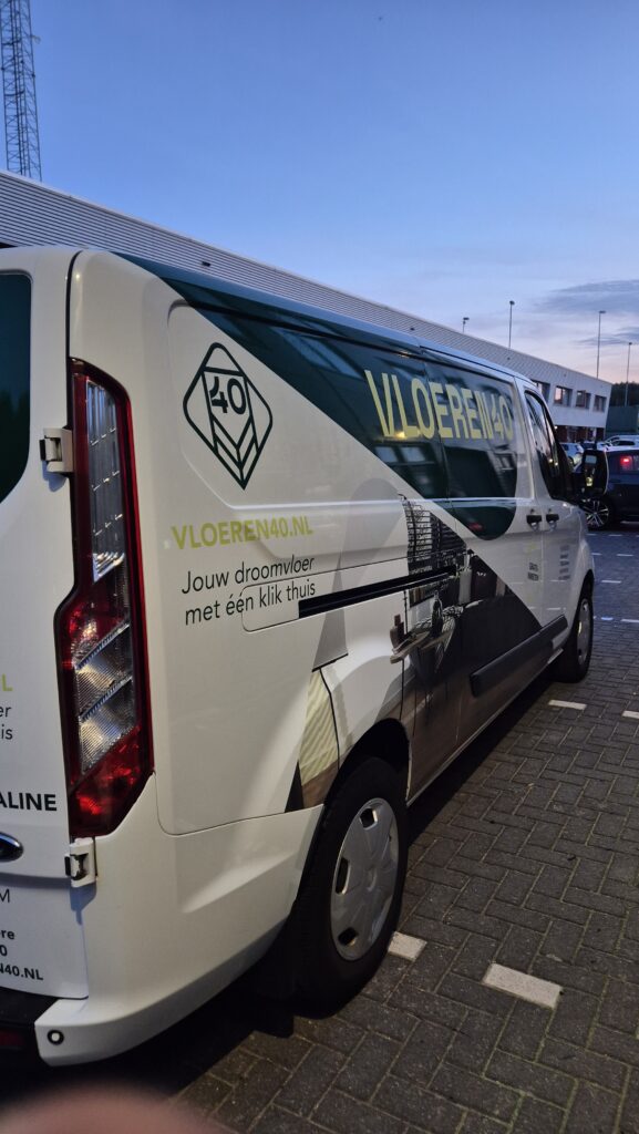 Zijkant van een bestelbus met belettering