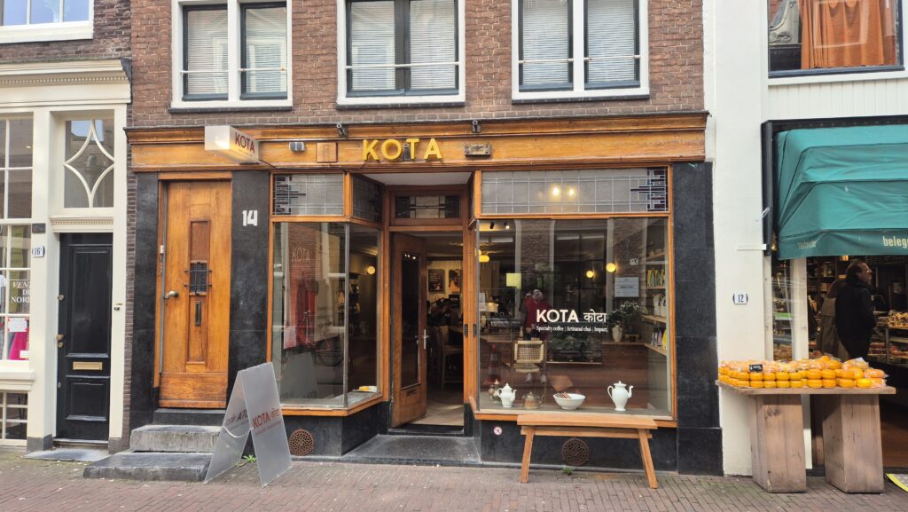 20260306_114853 Winkelpui van Kota met lichtreclame en raambelettering