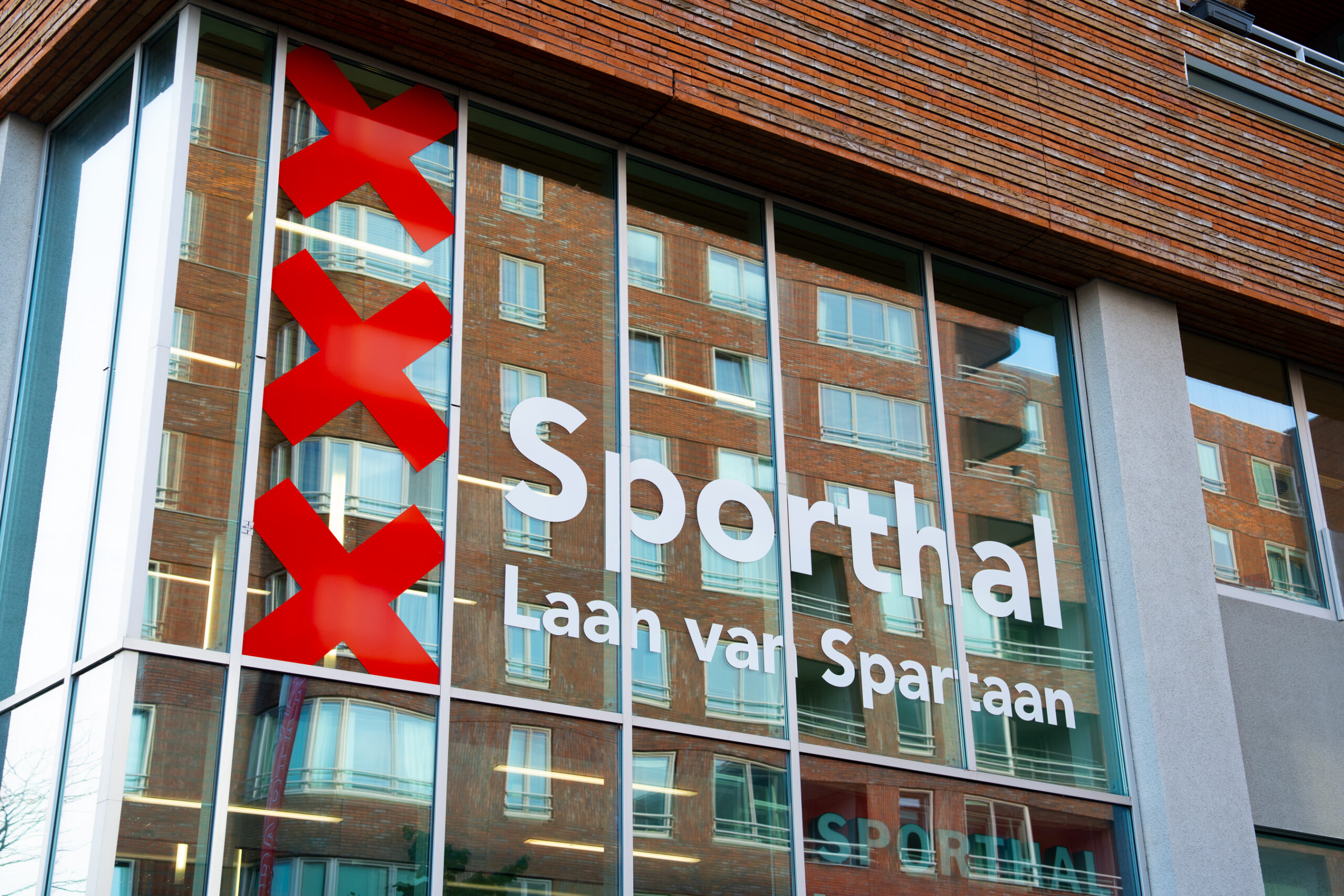 Sporthal Laan van Spartaan met raamstickers op de glazen gevel
