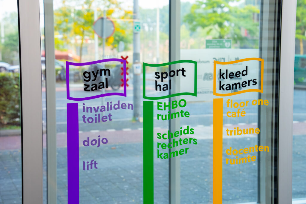Glazen deuren met gekleurde deurfolie naar gymzaal, sporthal en kleedkamers