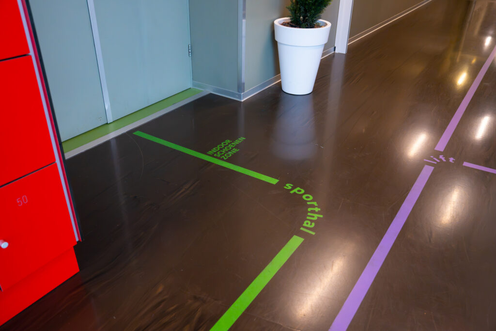 Looplijnen in groen en paars op een donkere vloer
