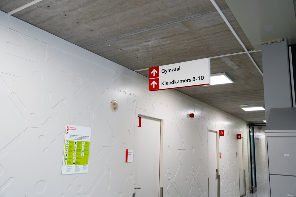 Rood-wit richtingbord en kamernummer in een gang